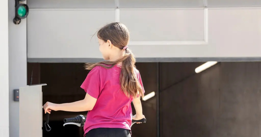 Girl with bike near garage door open.